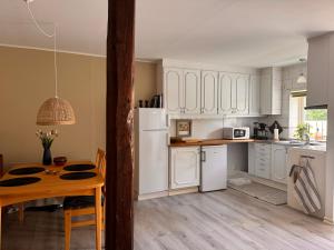 a kitchen with white cabinets and a wooden table at Enkelheten i Kivik in Kivik
