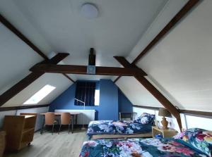 a attic room with two beds and a table at Rombaut Restout in Lokeren