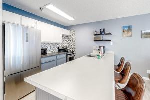 eine Küche mit weißer Arbeitsplatte und Kühlschrank in der Unterkunft Snowblaze Studio in Winter Park