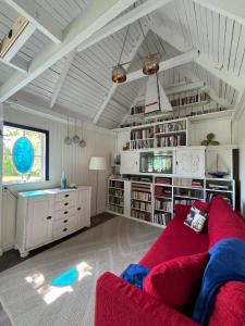 ein Wohnzimmer mit einem roten Sofa und Bücherregalen in der Unterkunft Captain's cabin in Flen