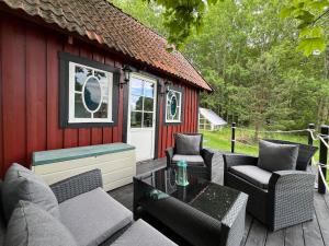 eine Terrasse mit Stühlen und einem Tisch und ein Gebäude in der Unterkunft Captain's cabin in Flen