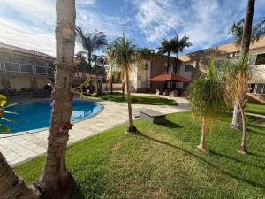 a resort yard with a swimming pool and palm trees at Hotel Morada do Sol in Chavantina