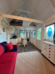 ein Wohnzimmer mit einem roten Sofa und eine Küche in der Unterkunft Captain's cabin in Flen