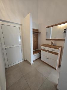 a bathroom with a dresser and a large mirror at Apartmani Kovač in Stara Novalja +10 photos