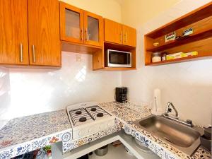a kitchen with a stove and a sink at Bungalow Kuaa in Puerto Ángel