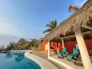a resort with chairs and a swimming pool at Bungalow Kuaa in Puerto Ángel