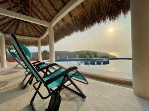 a pair of chairs sitting next to a swimming pool at Bungalow Kuaa in Puerto Ángel