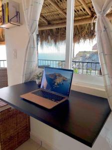 a laptop computer sitting on a desk in front of a window at Bungalow Kuaa in Puerto Ángel +62 photos