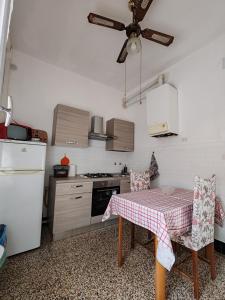 eine Küche mit Tisch und Deckenventilator in der Unterkunft Paloma-fly in Forlì