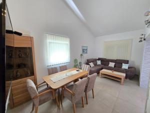 a living room with a table and chairs and a couch at Apartmani Kovač in Stara Novalja