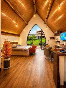 a bedroom with a bed and a living room at Recanto da Natureza in Brotas