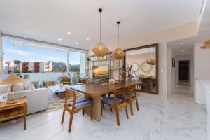 a dining room and living room with a table and chairs at 3BR Apartment Beach & Dining Steps Away in Cabo San Lucas