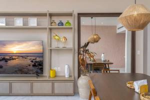 a living room with a television on a wall at 3BR Apartment Beach & Dining Steps Away in Cabo San Lucas