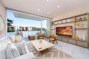 a living room with a couch and a tv at 3BR Apartment Beach & Dining Steps Away in Cabo San Lucas