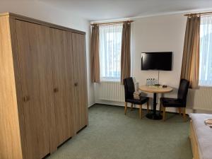 a hotel room with a large cabinet and a table at Ubytování Jívka 86 in Jívka
