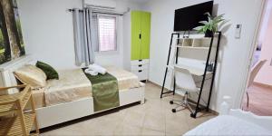 a bedroom with a bed and a desk in it at BLAGO home Los Angeles 3 in Eilat