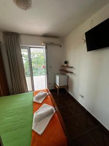 a bedroom with an orange and green bed and a window at Villa primorka in Boreti