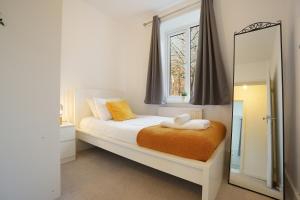 a bedroom with a bed with a mirror and a window at Central Sheffield stylish stay in Sheffield