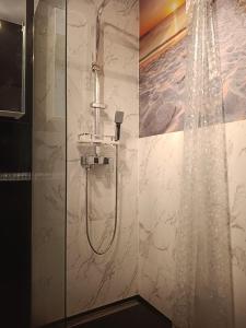 a shower with a shower curtain in a bathroom at Azyl in Darłówko