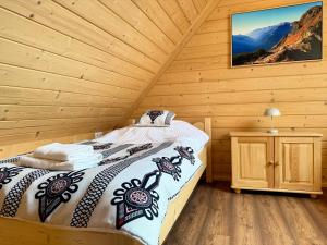 a bedroom with a bed in a wooden cabin at Apartamenty 242E in Chochołów