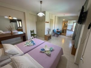 a bedroom with two beds with towels on them at Ta Kalamakia Apartments in Vatera