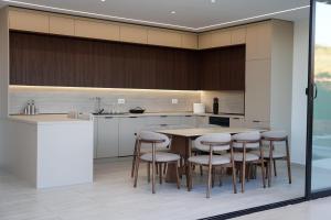a kitchen with a table and chairs and a counter at Lakeside Palms in Tirana