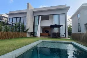 a house with a swimming pool in the yard at Oka Milagres Beachfront Condominium By MME in Barra do Camaragibe
