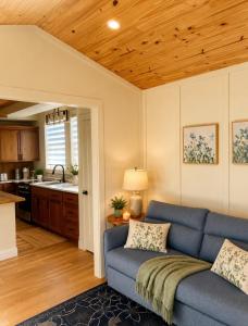 a living room with a blue couch and a kitchen at Honey & Hook Tiny Home with Breakfast in St. Catharines