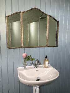 a bathroom sink with a mirror on the wall at Sveas B&B Ullared in Ullared +24 photos