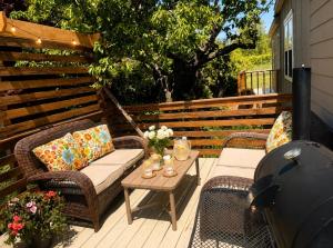 a patio with wicker chairs and a table with a grill at Honey & Hook Tiny Home with Breakfast in St. Catharines
