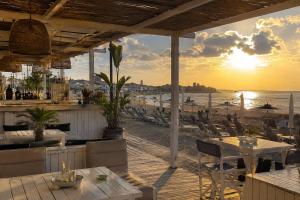 a restaurant with a view of the beach at sunset at Caty House in Nettuno