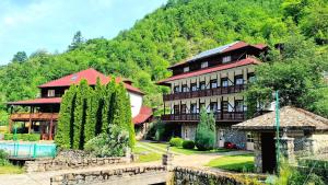 a large building in front of a mountain at Etno Selo VRELO & Camping in Berane