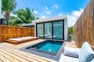 a deck with a swimming pool and a wooden fence at LuxVilla Modern Beachfront in the Village in Caye Caulker