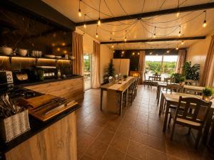 a restaurant with tables and chairs and a kitchen at Willa Fenix Busko-Zdroj Pokoje Goscinne & Agroturystyka in Busko-Zdrój