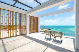 a dining room with a view of the ocean at LuxVilla Modern Beachfront in the Village in Caye Caulker
