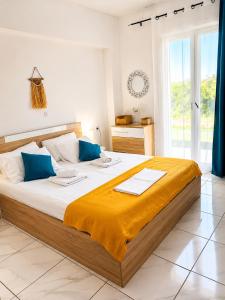 a bedroom with a large bed with blue pillows at 4T apartments in Argostoli