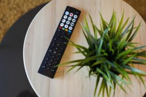a remote control sitting on a table next to a potted plant at Central Sheffield stylish stay in Sheffield
