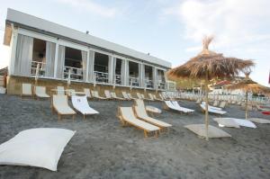 a group of chairs and umbrellas on a beach at Caty House in Nettuno