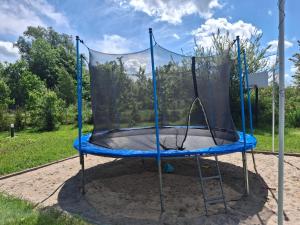 a blue trampoline with a net on it at Domki Black Pearl Mielno basen sauna jacuzzi in Mielno