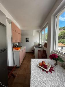 a kitchen with a table with a plate of fruit on it at Villa primorka in Boreti