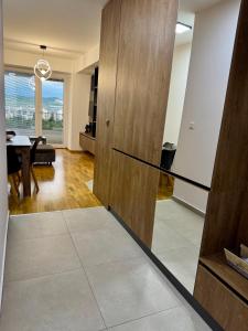 a living room with a wooden door and a table at Skyline Apartment Skopje in Madžari