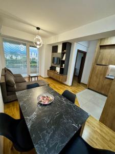 a living room with a table and a couch at Skyline Apartment Skopje in Madžari