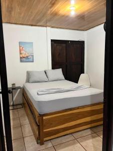a bedroom with a bed with a wooden headboard at Casa KAFRA in Hone Creek