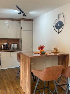 a kitchen with a wooden table and two bar stools at Vila Kraljica Une in Bosanska Krupa