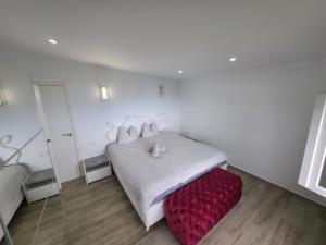 a bedroom with a white bed and a red ottoman at Typical Canarian House private jacuzzi, sauna, gym, Finca Conejo Taucho Adeje by Aqua Vista Tenerife in Adeje +46 photos