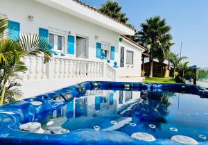 a blue swimming pool in front of a house at Typical Canarian House private jacuzzi, sauna, gym, Finca Conejo Taucho Adeje by Aqua Vista Tenerife in Adeje