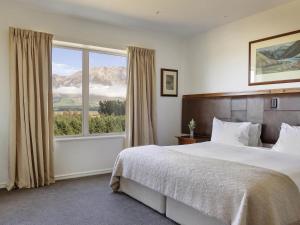 a bedroom with a bed and a large window at Fable Terrace Downs Resort by MGallery in Windwhistle