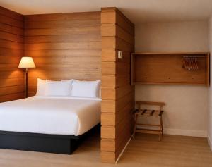 a bedroom with a bed and a wooden wall at Hôtels Gouverneur Rimouski in Rimouski