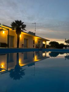 a house with a palm tree and a swimming pool at Casa vacanza le tre palme in Syracuse