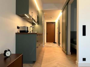 a kitchen with green cabinets and a clock on the counter at Oru Park & Sea Apartment in Tallinn +2 photos